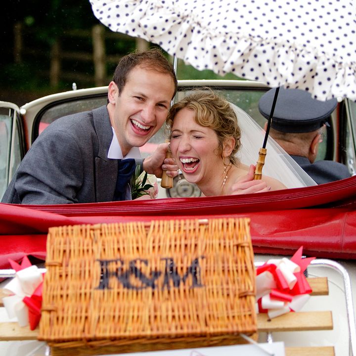 Happy couple looking out from the back of Cassie, a Morris Minor Convertible